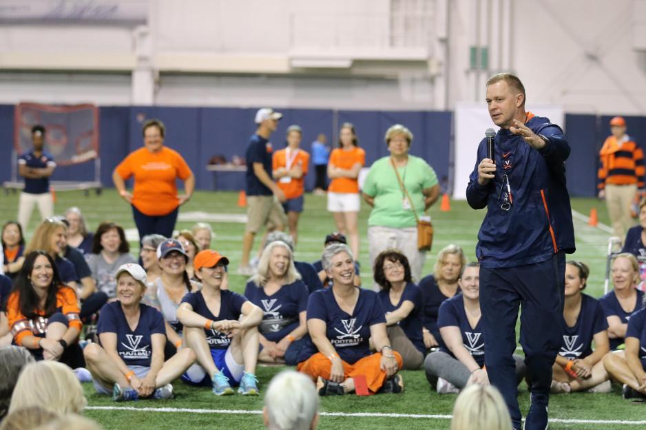 Bronco Mendenhall chats with female participants of the football team clinic