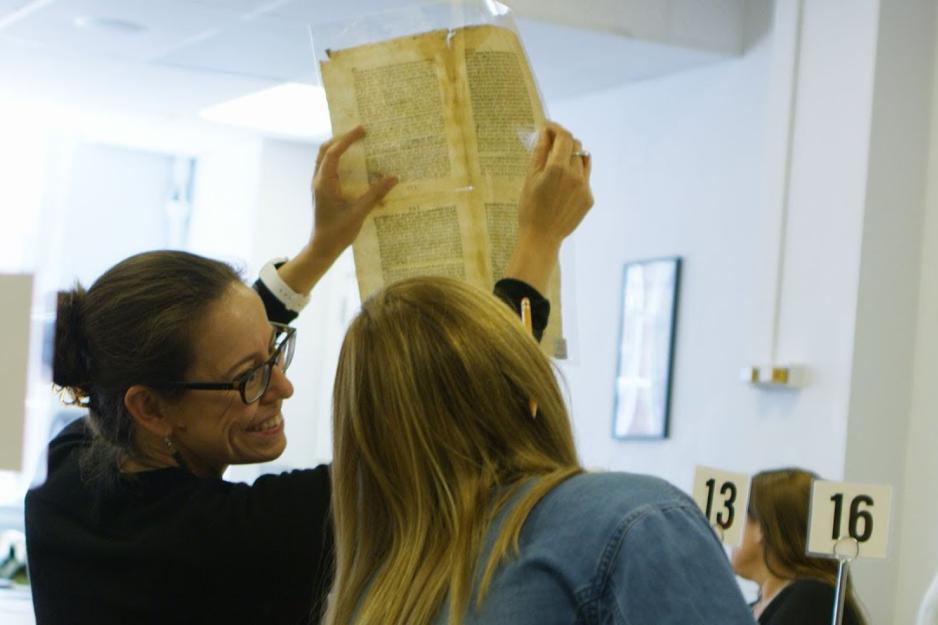 Person holds up an old page from a book