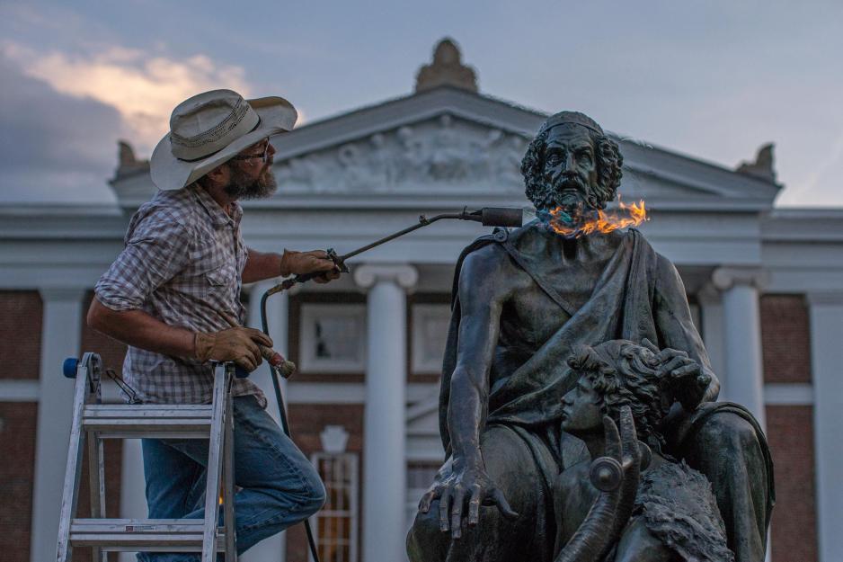Person Places flames on the Homer statues head