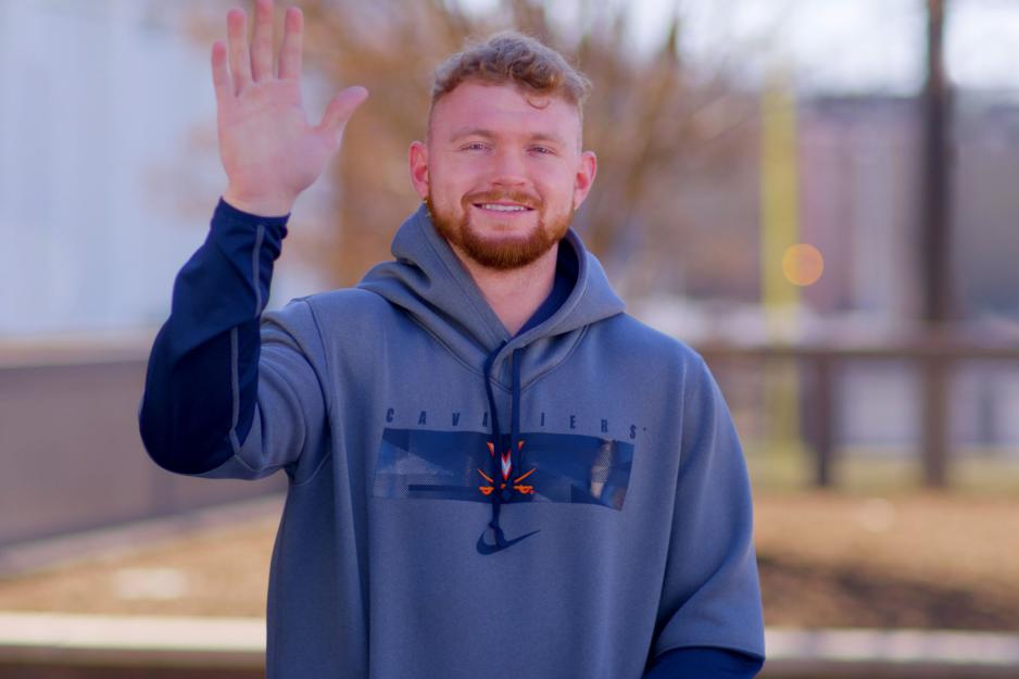 Brennan waiving at the camera with his right hand