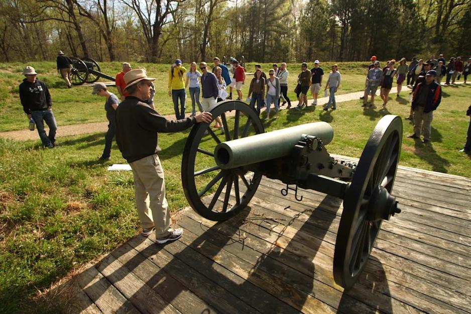  Civil war cannon on a platform with a group of people around it listening to a tour guide