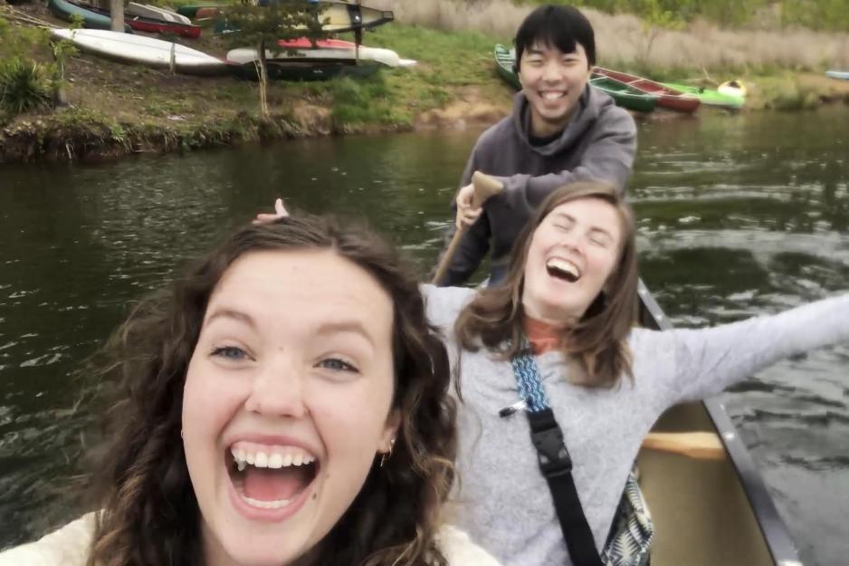 Three friends in a canoe taking a selfie