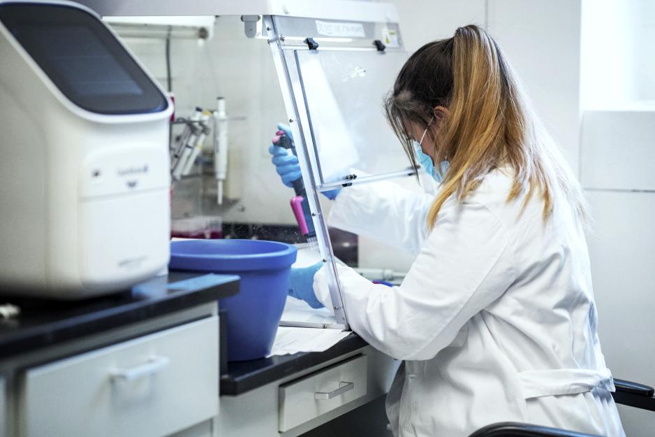 Woman placing saliva samples into test tubes