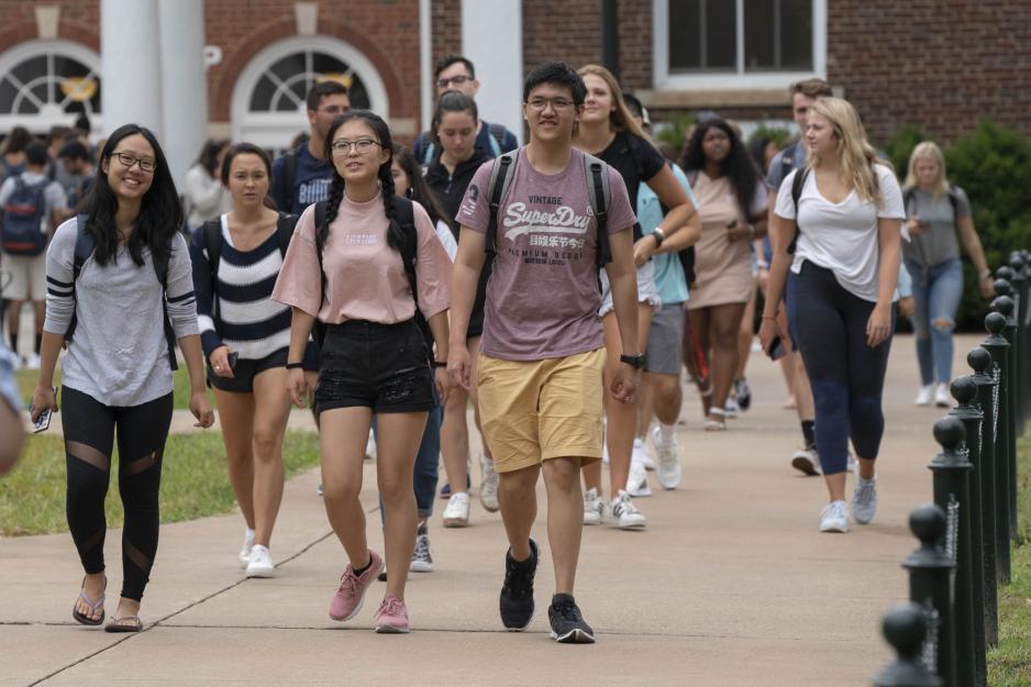 Students walking on a sidewalk to and from classes