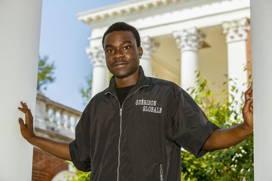 Davon Okoro standing between two pillars with his hands on both