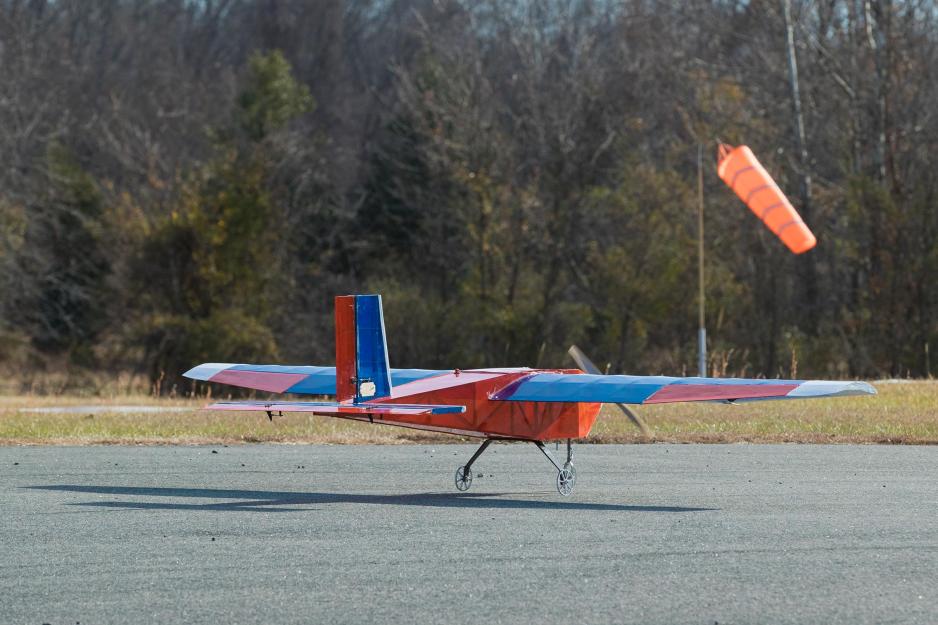 small Orange, blue, and white, plane moving on the tarmac