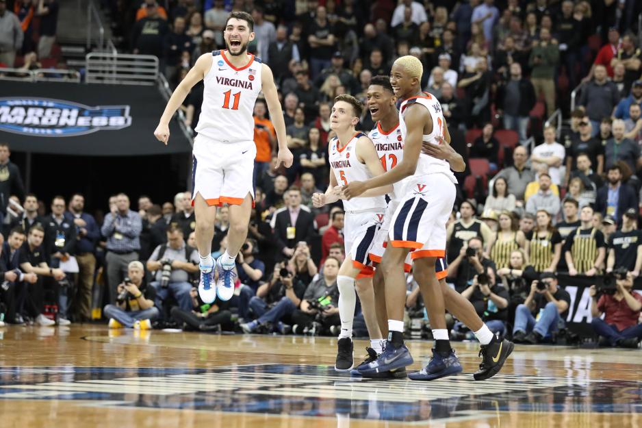 UVA basketball team members celebrating on the court after their victory