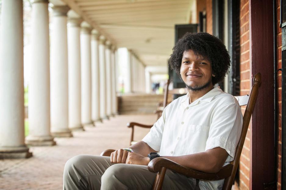 Ja’Mel Reed sitting in a rocking chair outside of his Lawn room