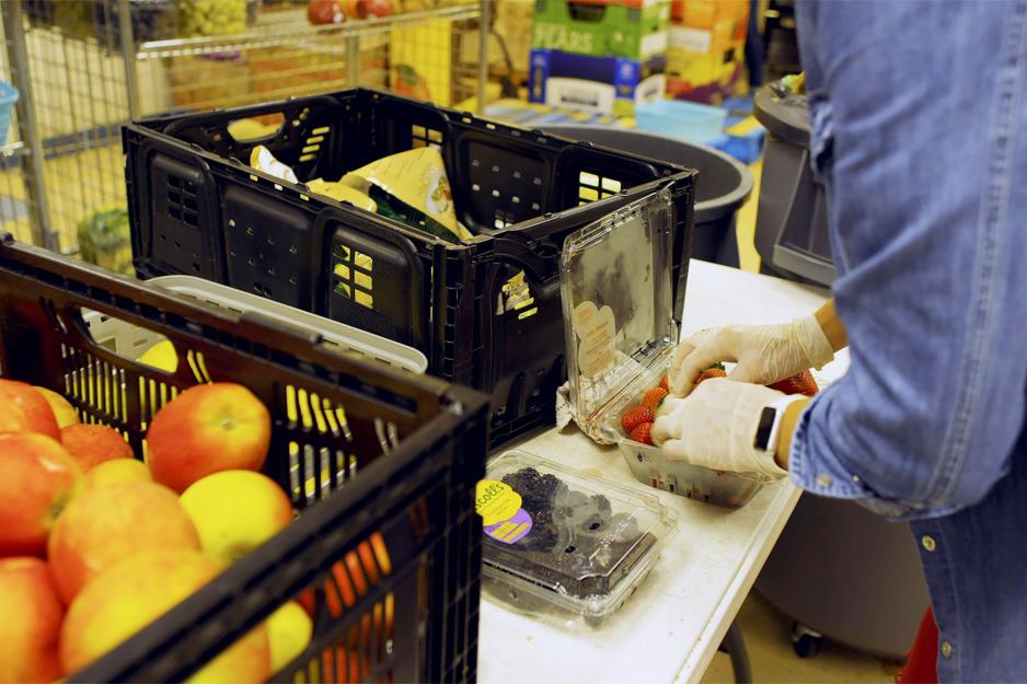 Person packing strawberries into a plastic container