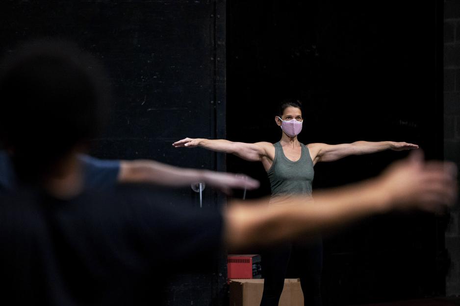 Marianne Kubik leads a group class in movement with her arms stretched out to her sides