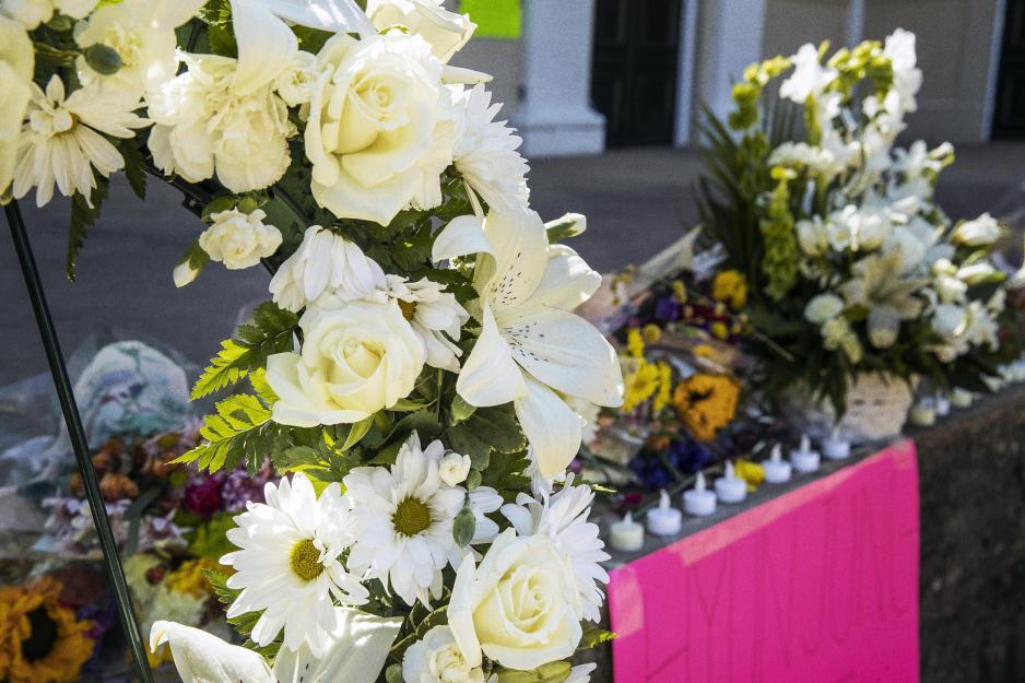 White memorial flowers left on the street with candles in Atlanta