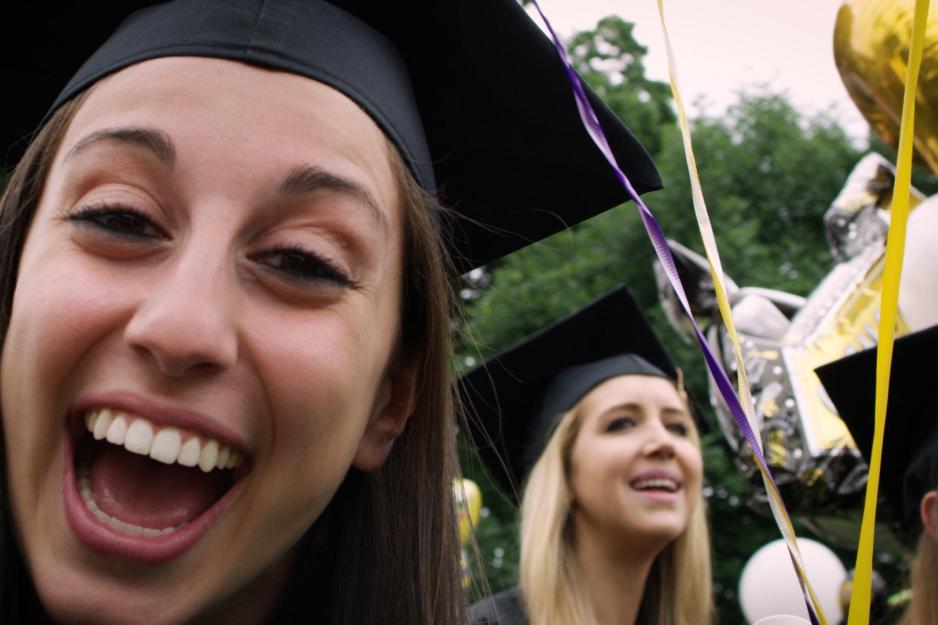  Happy graduates smile while taking a selfie