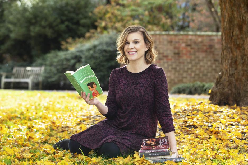 Cristina Richieri Griffin, sitting in the leaf covered grass reading books