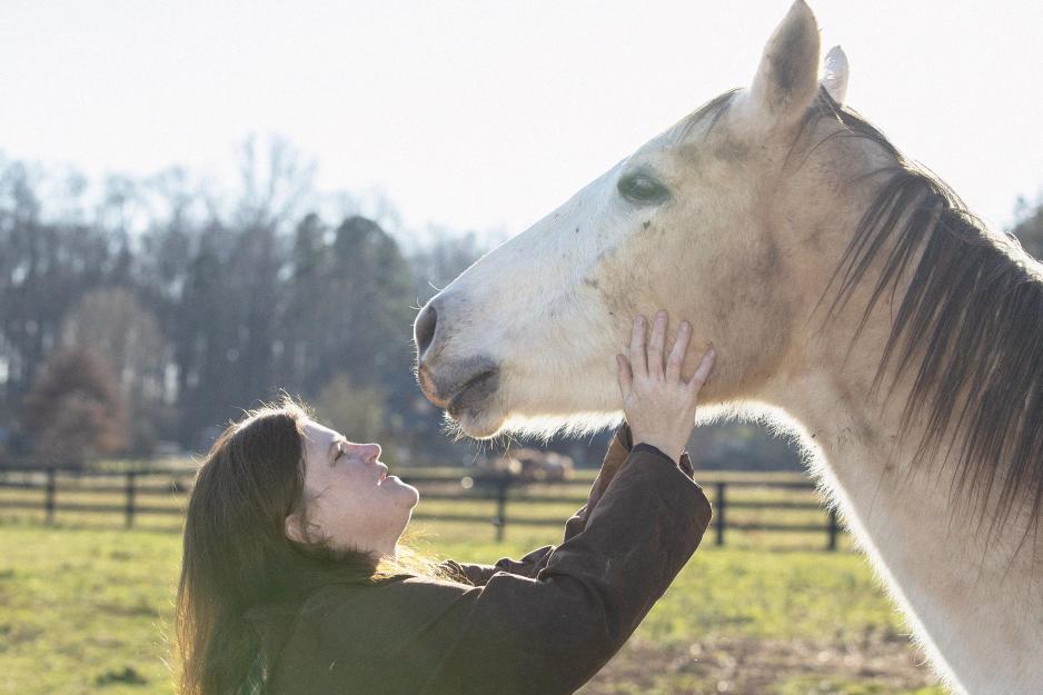Sarah Osborn Barwick rubbing white horses, Lane's, face