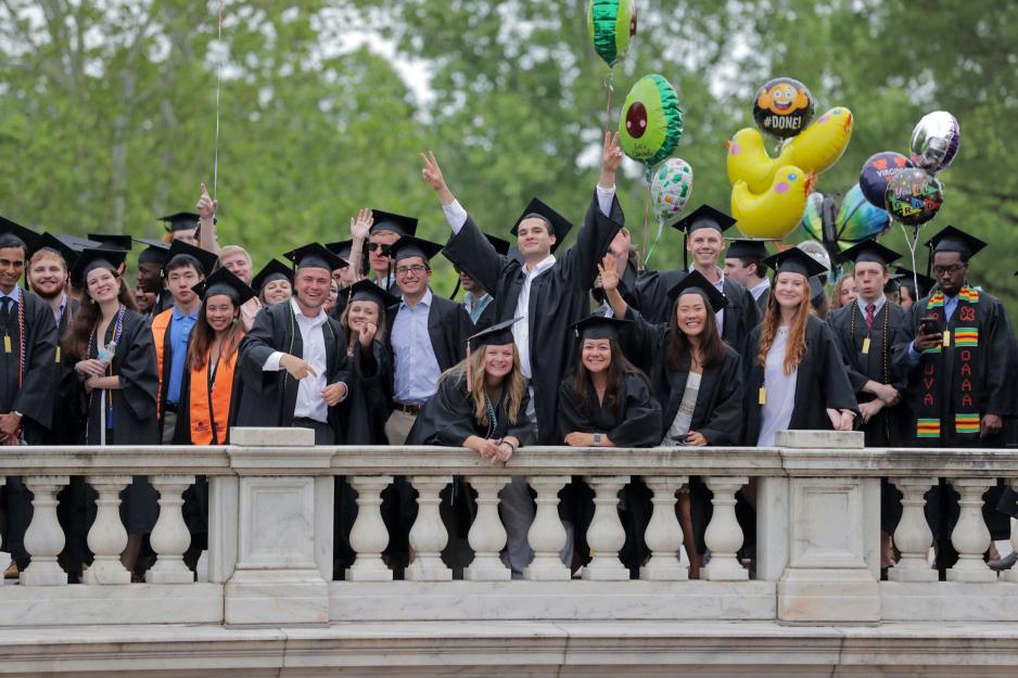 Graduates stand on the Rotunda smiling for the camera