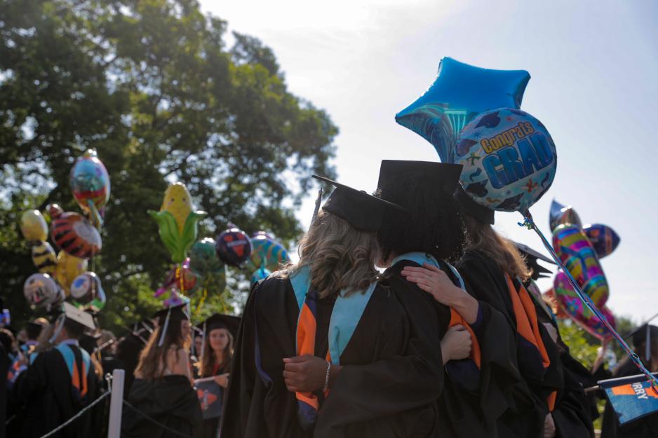 Graduates stand for a picture together with balloons