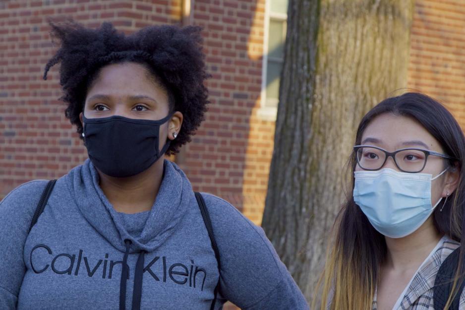 Two students standing together wearing masks
