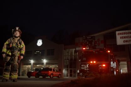 Portrait of Ali Kyle in her fire fighter uniform outside the emergency room.