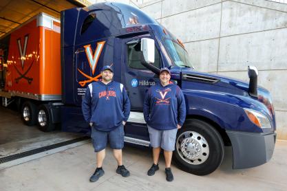 Portrait of Dennis Putnam and Jason Kibbe stand outside the UVA football equipment truck.