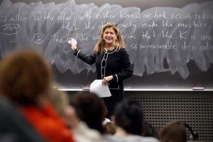 Sherri Moore lecturing in a UVA class gesturing at a chalkboard.