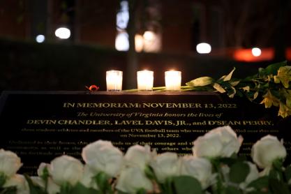 Close up of white roses and csndles by the memorial plaque for Devin Chandler, D’Sean Perry and Lavel Davis Jr.