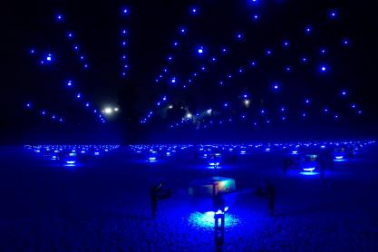 Drones lifting off the ground at night in unison 