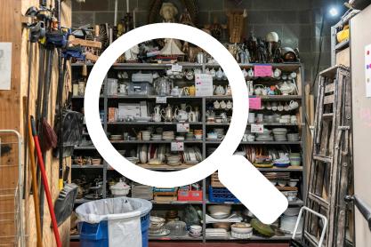 Magnifying glass illustration over a photo of the Ruth Caplin Theatre Prop Room