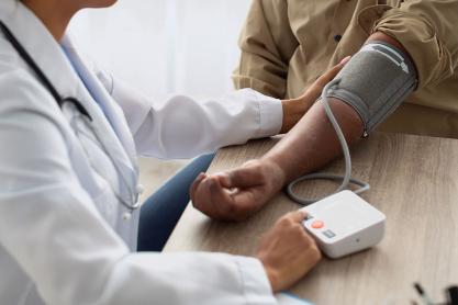 A doctor tests a patient's blood pressure using a cuff