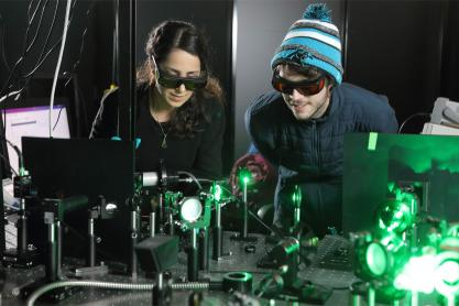 Two students looking over the layout of the plasma ray