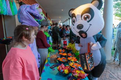 An inflatable panda selecting candy from a Monster Inc. themed table