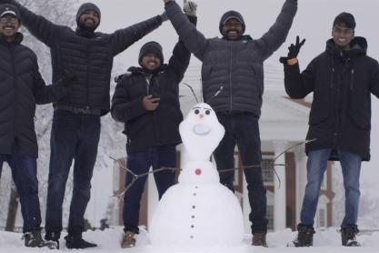 Students with snowman they made in front of the Rotunda
