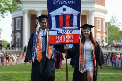 Two graduating students carry the Class of 2022 flag