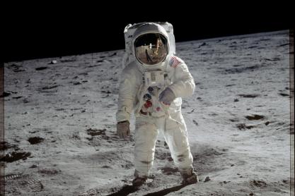 Buzz Aldrin walking on the moon in a white space suite