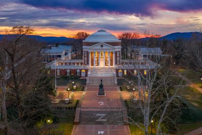 The Rotunda with blue ridge mountains and a red, orange, and yellow sunset