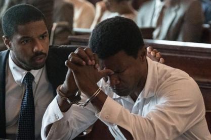 Still frame from the movie Just mercy.  A black attorney comforts his client who is sitting in handcuffs with their head on their hands