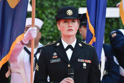 Kayla Winslow in her military uniform standing at a microphone