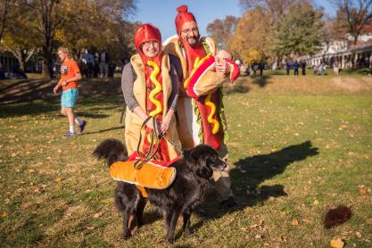 Parents, baby, and a dog, all dressed up as hotdogs