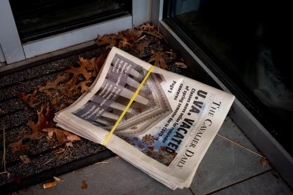 A bundle of copies of the Cavalier Daily sit in the entryway of a building