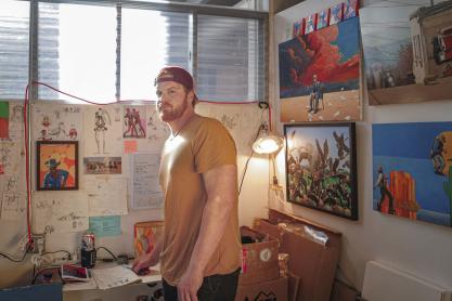 Will Barker stands in art studio