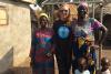 Engineering alumna Kate Clopeck stands with two local solar power entrepreneurs and their children.