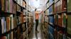 A person pulling a book off a shelf in a library