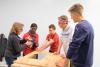 Student Chris Sausa, right, and his “little brother” Johan, center, along with student Garrett Lukens, build doghouses with Sharon Shafer from Houses of Wood and Straw, left, and NBC-29 reporter Moriah Davis.