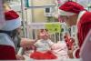Santa Claus, right, portrayed by neonatologist Dr. Robert Sinkin, and “Mrs. Claus” visit a patient in the NICU on Wednesday. (Photos by Sanjay Suchak, University Communications)