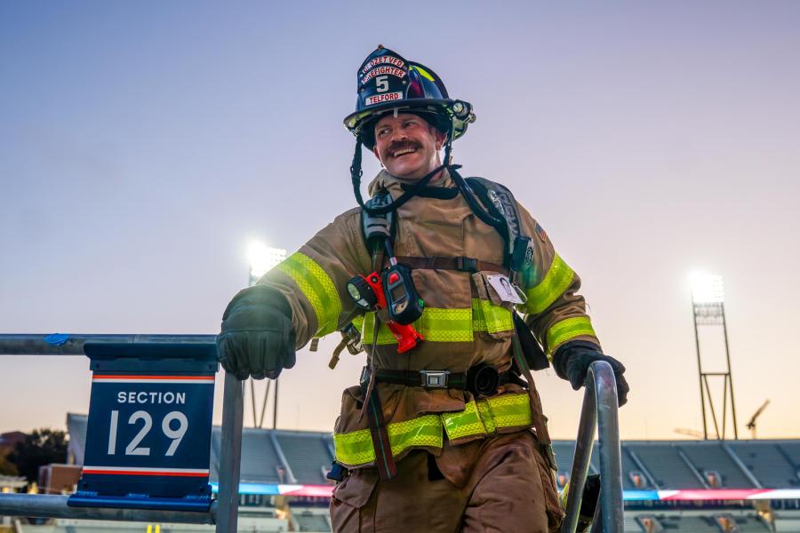 a firefighter climbing the stairs of UVA Scott Stadium during the 9/11 remembrance stair climb event for 2025