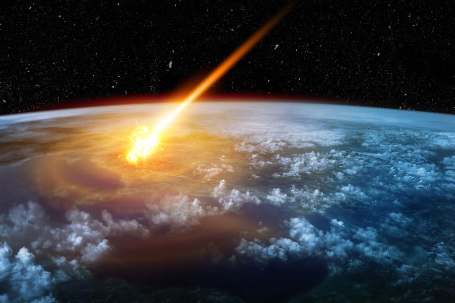 An illustration of space showing an asteroid reaching the Earth's surface.