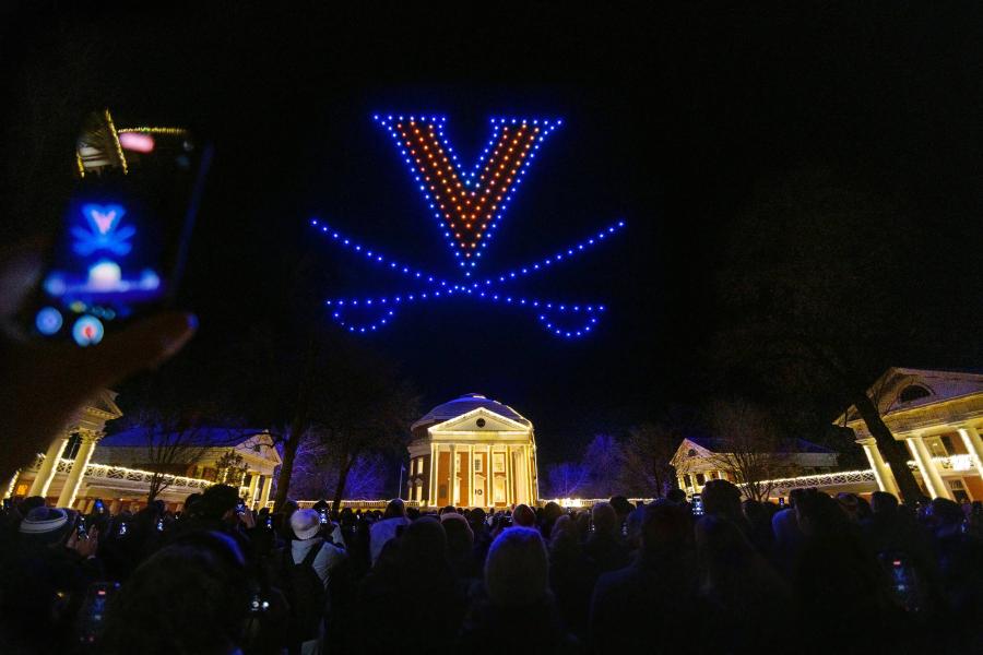 the UVA Rotunda lit at night with a drone light show over top in the formation of a ‘V-Saber’