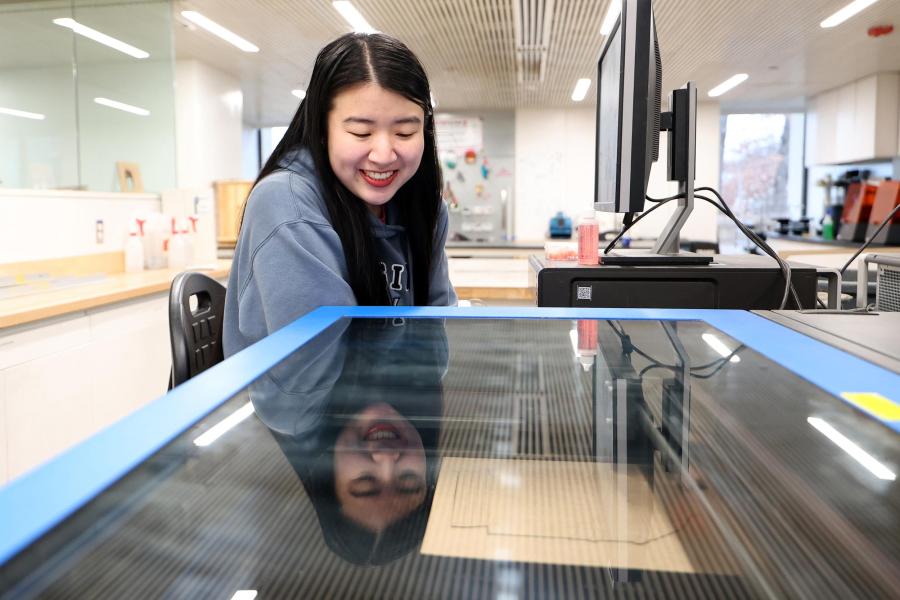 UVA School of Architecture grad student Nola Timmins looks at a 3D printer