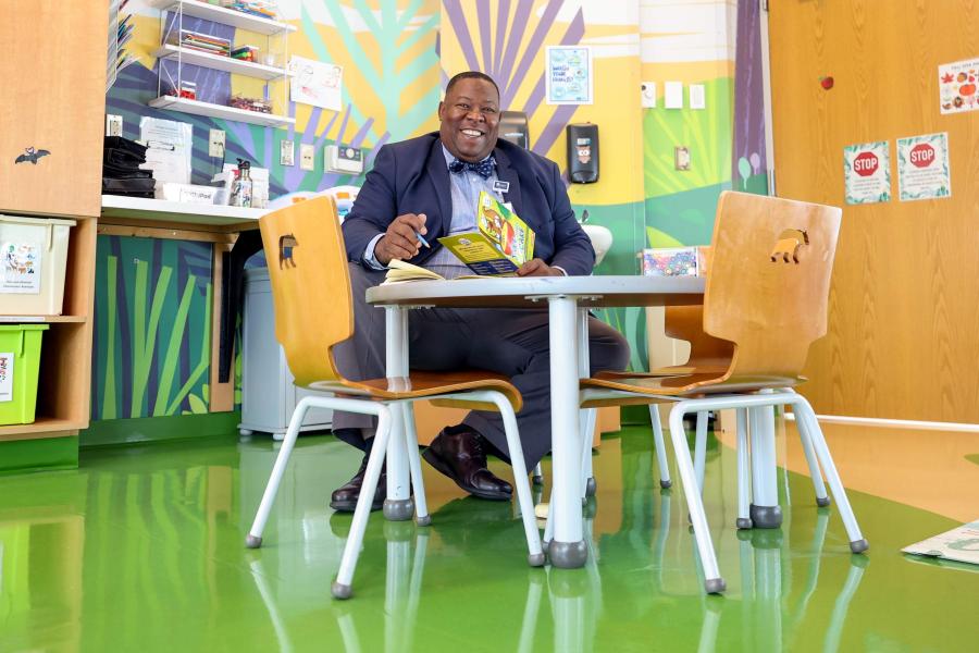 Eric Johnson seated at a table with open chairs in a classroom at UVA Health Children’s