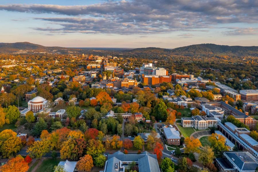 aerial photo of Grounds at UVA and the surrounding city of Charlottesville taken during a fall evening.