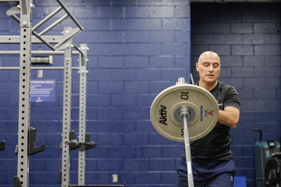 Hamid “Jim” Karimi putting a large weight on a bar at the North Grounds Recreation Center